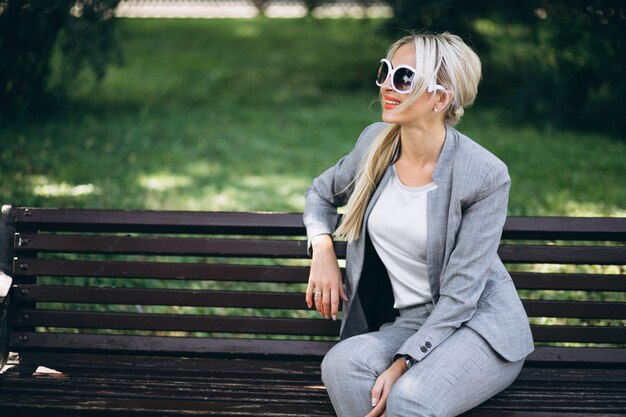 Geschäftsfrau, die im Park sich entspannt