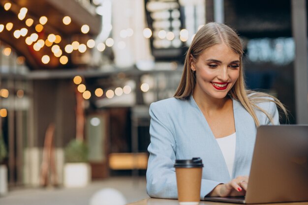 Geschäftsfrau, die in einem Café am Computer arbeitet und Kaffee trinkt