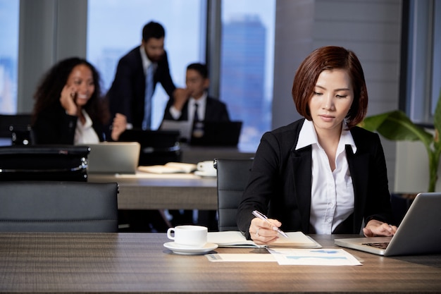 Geschäftsfrau, die mit Dokument im Büro arbeitet