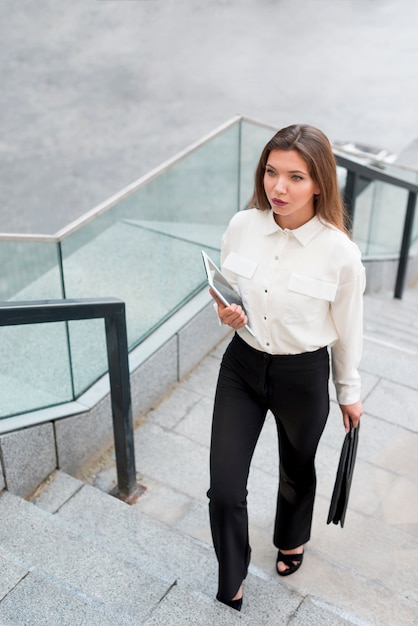 Kostenloses Foto geschäftsfrau, die oben die treppe klettert