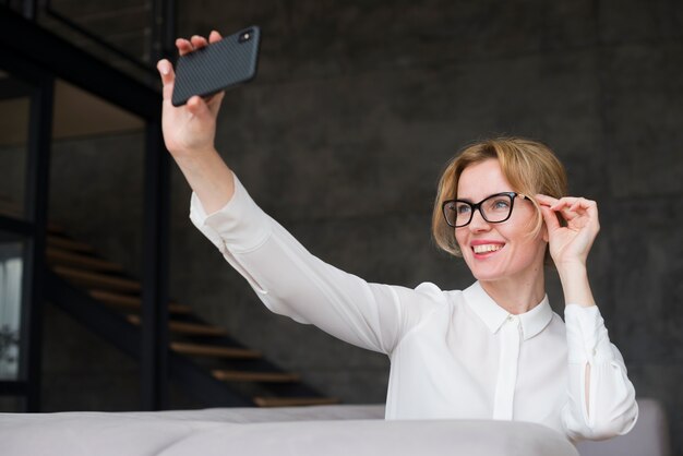 Geschäftsfrau, die selfie mit Smartphone nimmt