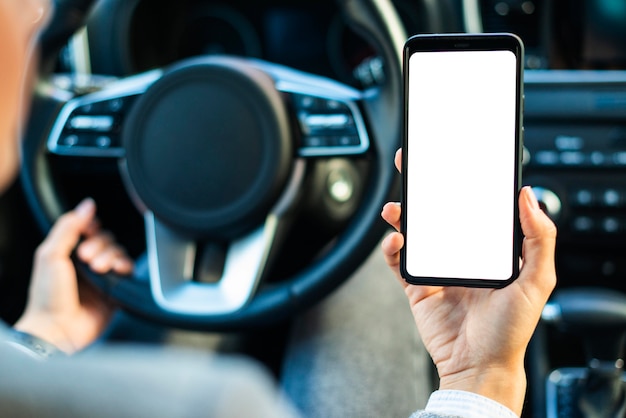 Geschäftsfrau, die Smartphone im Auto hält