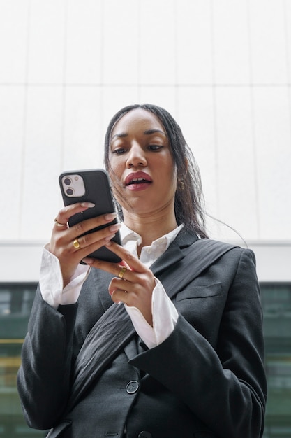 Kostenloses Foto geschäftsfrau, die smartphone überprüft