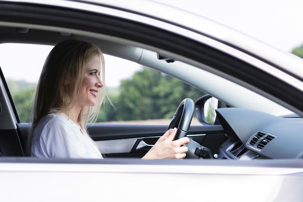 Geschäftsfrau, die sorgfältig mittleren Schuss des Autos fährt