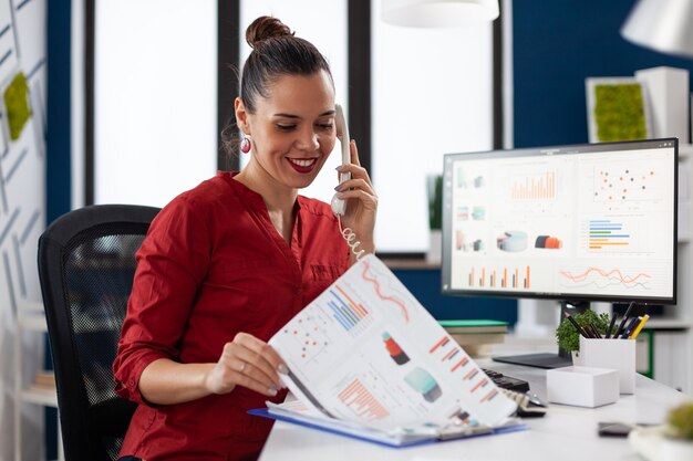 Geschäftsfrau im Firmenbüro, die Finanzstatistik überprüft