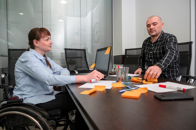 Kostenloses Foto geschäftsfrau im rollstuhl und orange haftnotizen