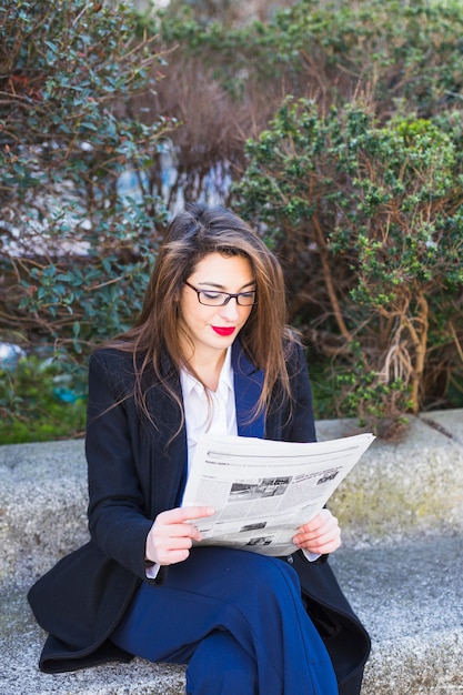 Kostenloses Foto geschäftsfrau liest zeitung draußen