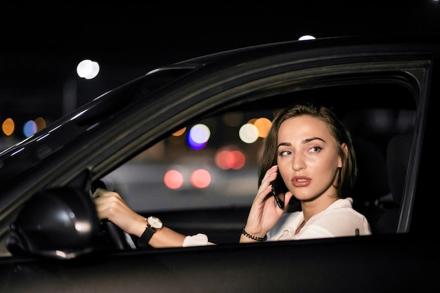 Geschäftsfrau mit dem Telefon im Auto