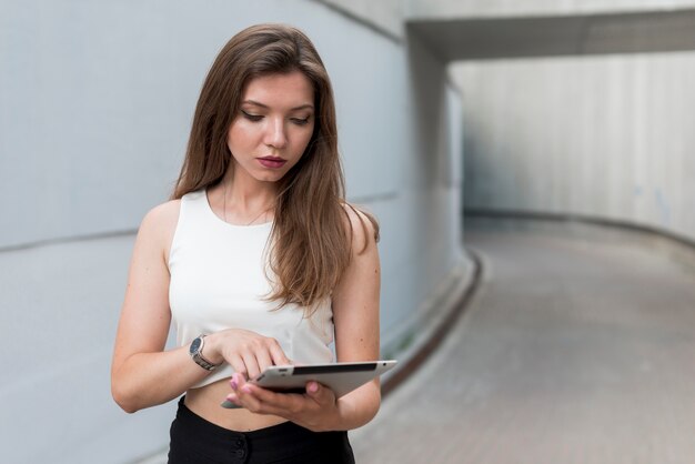 Geschäftsfrau mit einer Tablette in der Straße