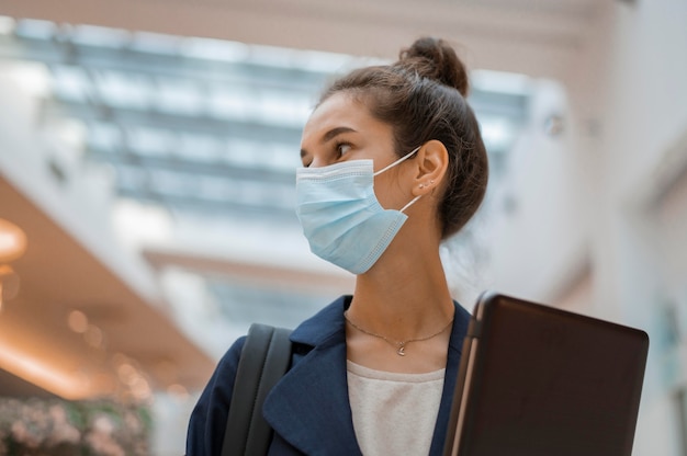 Kostenloses Foto geschäftsfrau mit gesichtsmaske wegsehen