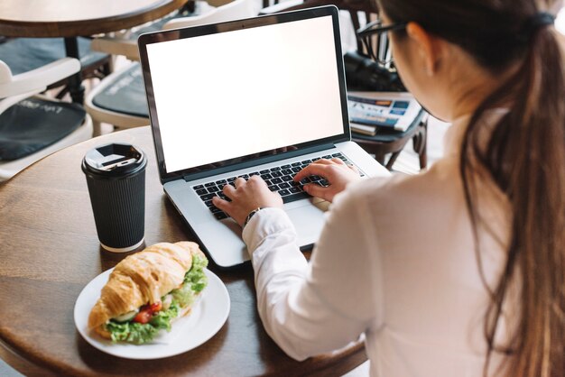 Geschäftsfrau mit Laptop in der Kaffeestube