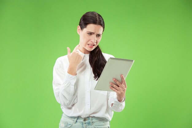 Geschäftsfrau mit Laptop. Liebe zum Computerkonzept. Attraktives weibliches Porträt in halber Länge vorne, trendiges grünes Studio-Hintergrundbild. Junge emotionale hübsche Frau. Menschliche Gefühle, Gesichtsausdruck