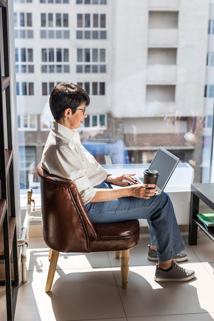 Geschäftsfrau mit Laptop und Kaffee