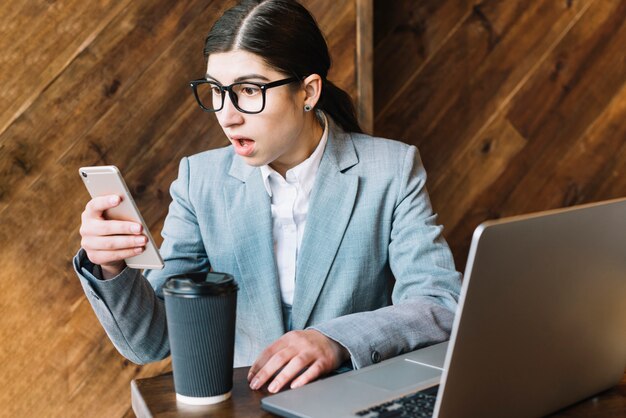 Geschäftsfrau mit Laptop und Smartphone in der Kaffeestube