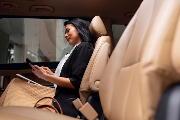 Geschäftsfrau sitzt auf dem Rücksitz eines Taxis