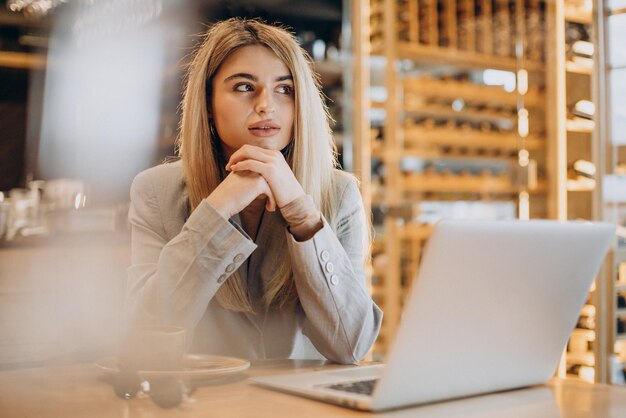 Geschäftsfrau sitzt im Café und arbeitet online