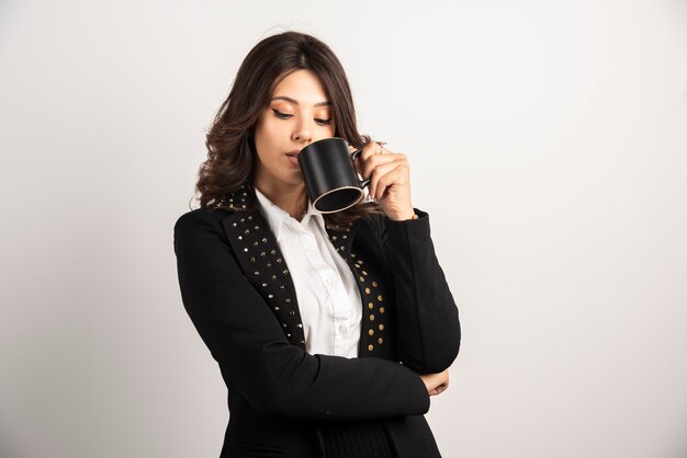 Geschäftsfrau trinkt eine Tasse Tee auf weiß