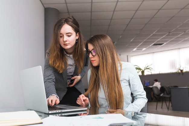 Geschäftsfrau zwei, die an Laptop arbeitet