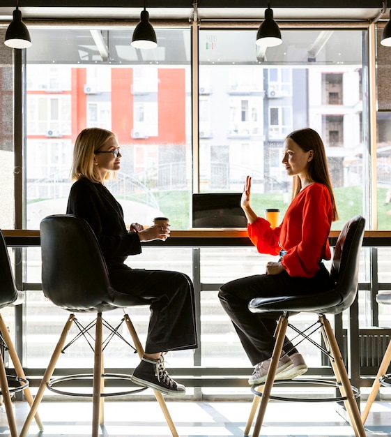 Geschäftsfrauen, die bei der Arbeit Gebärdensprache verwenden, um miteinander zu sprechen