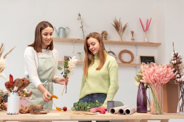 Geschäftsfrauen, die einen Blumenstrauß arrangieren