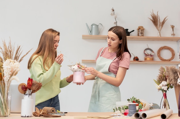 Geschäftsfrauen, die einen Blumenstrauß in ihrem Geschäft machen