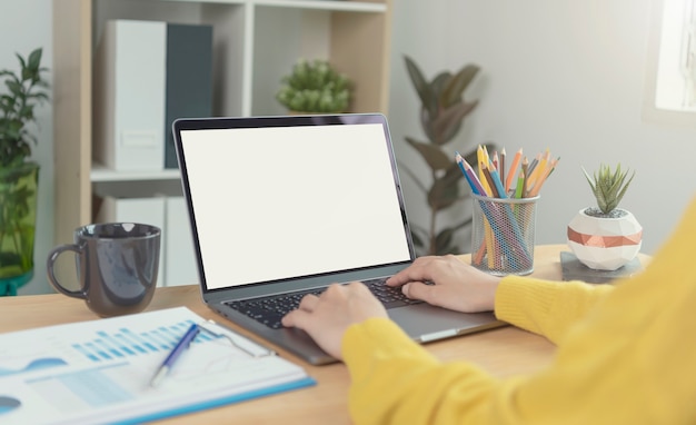 Geschäftsfrauhände, die Laptop mit leerem Bildschirm verwenden. Mock-up des Computermonitors. Exemplar bereit für Design oder Text.