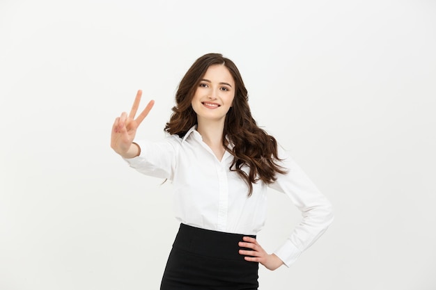 Geschäftskonzept-Geschäftsfrau, die Siegeszeichen zeigt und lokalisiert über weißem Hintergrund lächelt