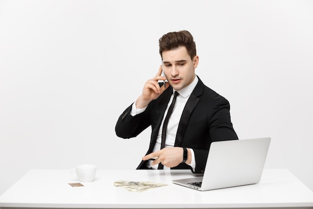 Geschäftskonzept Porträt junger erfolgreicher Geschäftsmann, der in hellem Büro mit Laptop arbeitet und spricht...