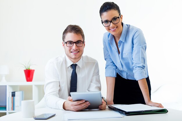 Geschäftsleute arbeiten im Büro mit digitaler Tablette.