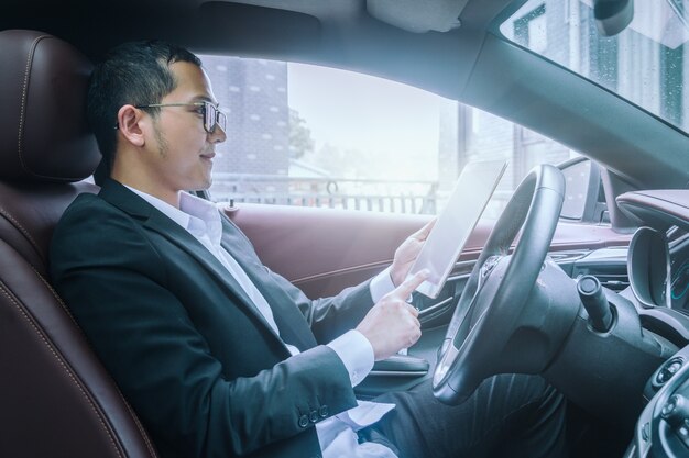 Geschäftsleute arbeiten mit Tablet-Computern in ihren Autos