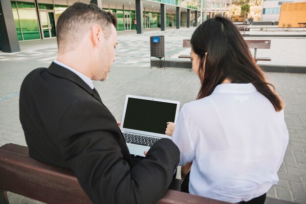 Geschäftsleute auf Bank mit Laptop