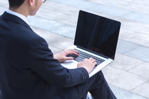 Geschäftsleute benutzen Laptops am Eingang eines Bürogebäudes