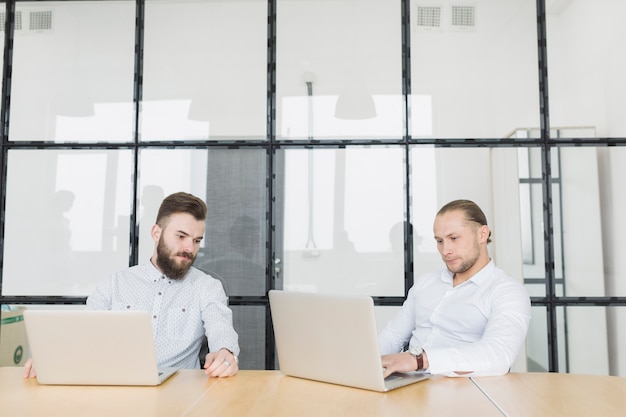 Kostenloses Foto geschäftsleute, die mit laptop im büro arbeiten