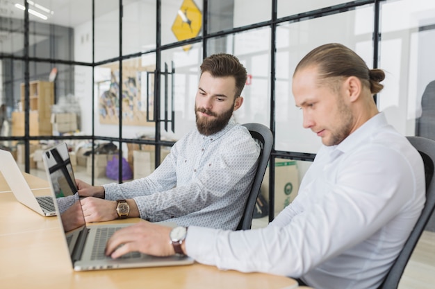 Kostenloses Foto geschäftsleute, die mit laptop im büro arbeiten