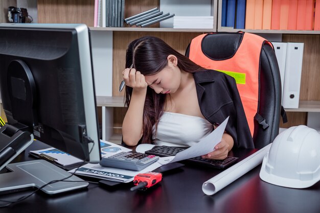 Geschäftsleute, Frauen, die mit Stress und Müdigkeit im Büro arbeiten.