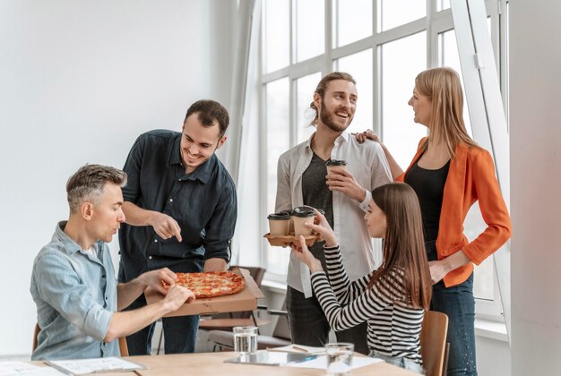 Geschäftsleute in der Mittagspause essen Pizza