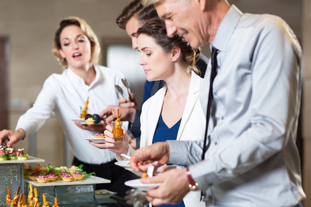 Geschäftsleute Serving sie selbst mit Snacks