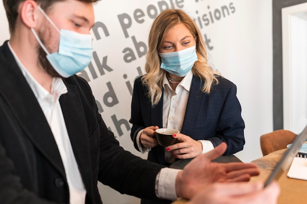 Geschäftsleute sprechen über ein neues Projekt, während sie medizinische Masken tragen