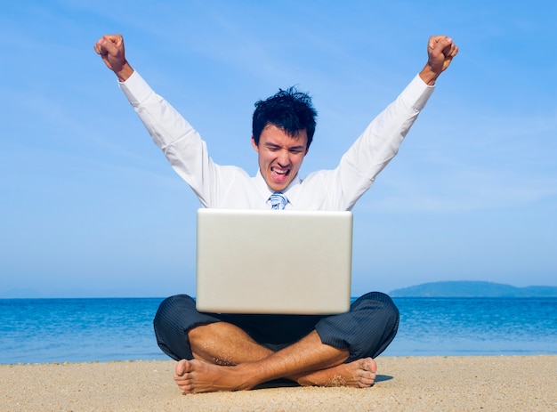 Geschäftsmann am Strand mit Laptop