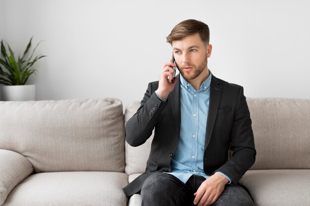 Geschäftsmann auf der Couch, die über Telefon spricht