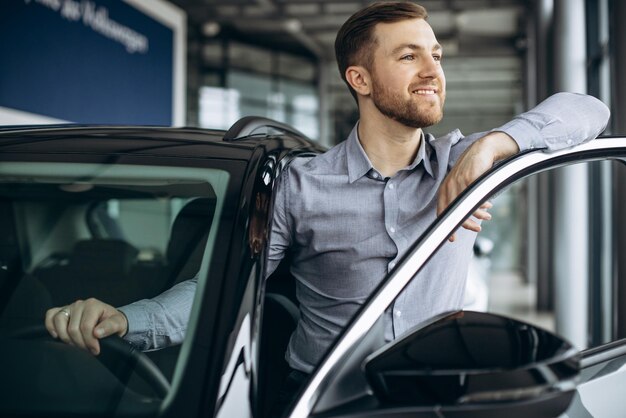 Geschäftsmann, der ein Auto im Autosalon wählt