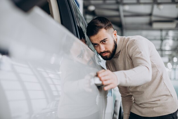 Geschäftsmann, der ein Auto in einem Autosalon wählt