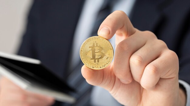 Geschäftsmann, der eine Bitcoin-Nahaufnahme hält