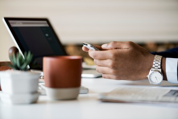 Geschäftsmann, der Handy bei der Arbeit verwendet