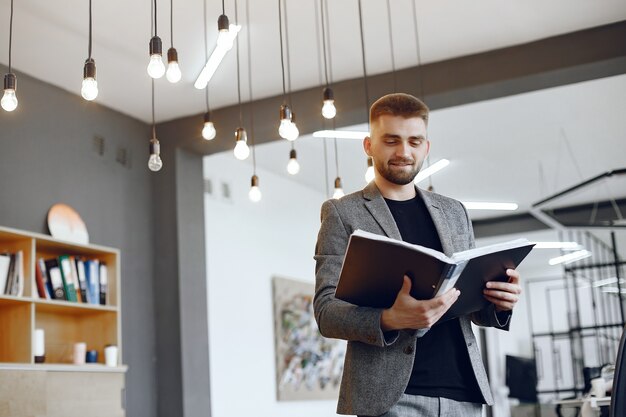 Geschäftsmann, der im Büro arbeitet. Mann hält einen Ordner. Guy sitzt im Büro