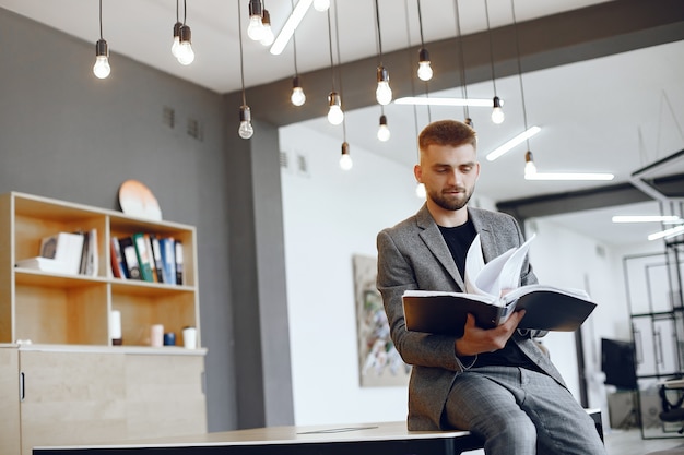 Geschäftsmann, der im Büro arbeitet. Mann hält einen Ordner. Guy sitzt im Büro