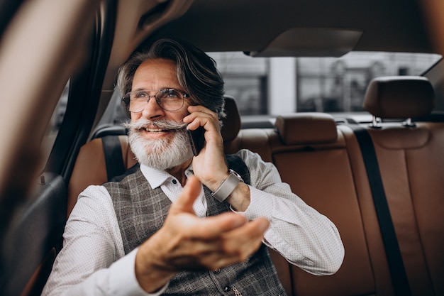 Geschäftsmann, der in seinem Auto hinten sitzt