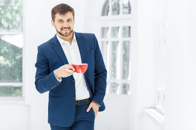 Geschäftsmann, der Kaffeepause hat, hält eine Tasse