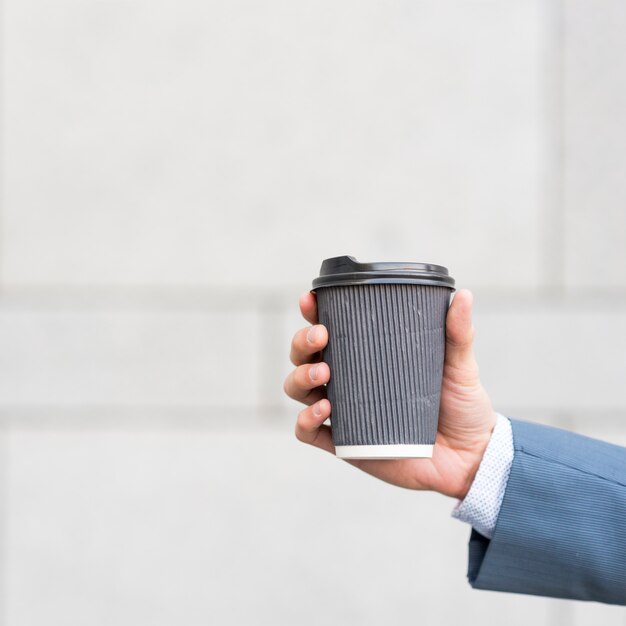 Geschäftsmann, der Kaffeetasse hält