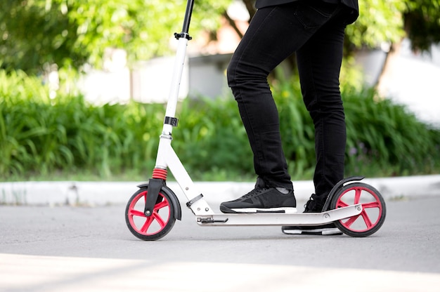 Geschäftsmann, der Roller draußen reitet